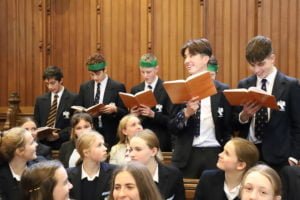 Boys standing in the chapel signing in a rehearsal