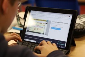 Child's hands working on a digital tablet