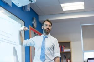 Male teacher domonstrating work on an interactive whiteboard