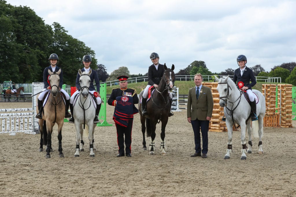 Group of horse riders on horse back receiving an award