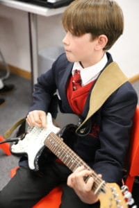 Prep School boy playing an electric guitar